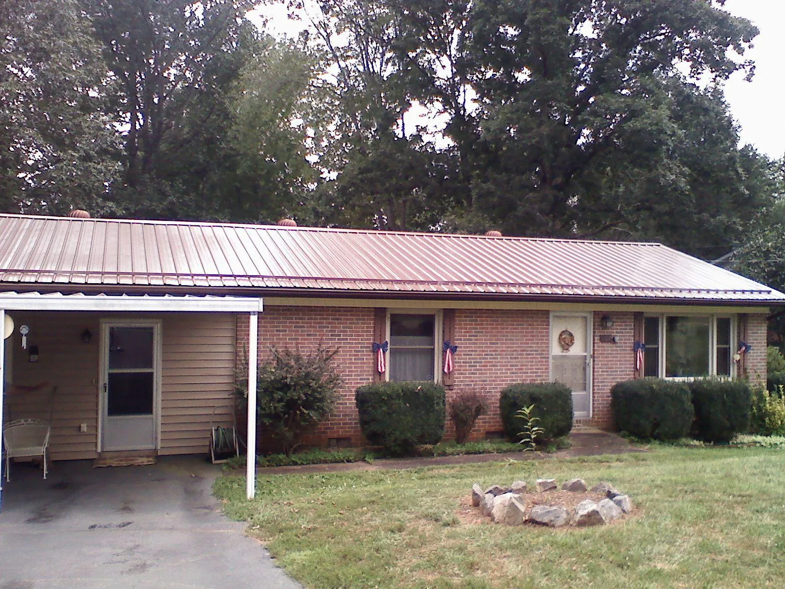 Bronze metal roof and carport on a brick ranch home — Roof Repair work by our crew in Belle Plaine